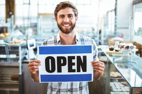 man holding up open sign