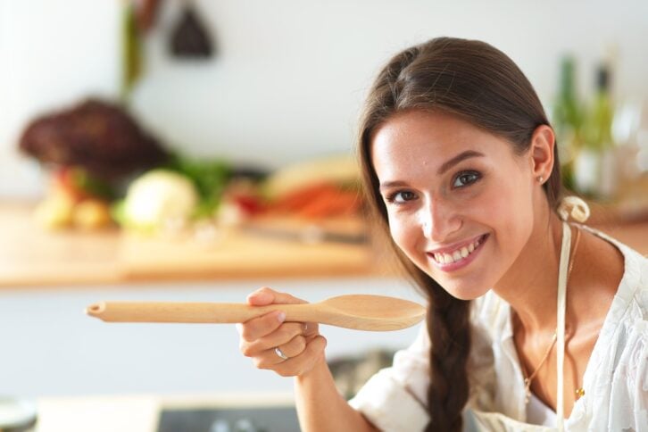 woman cooking with wooden spoon