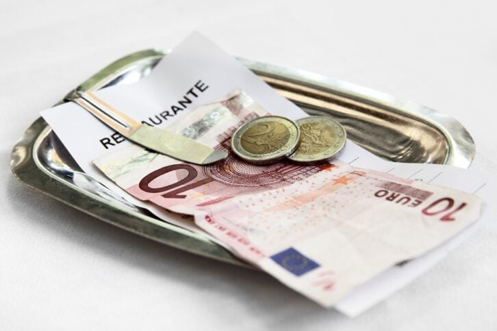 restaurant bill and money on metal tray
