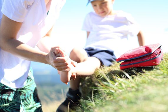 person helping child who twisted his ankle outdoors