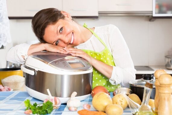 woman hugging her slow cooker in her kitchen