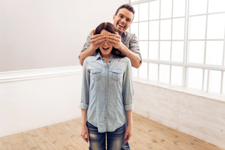 young couple is moving, standing in an empty new apartment