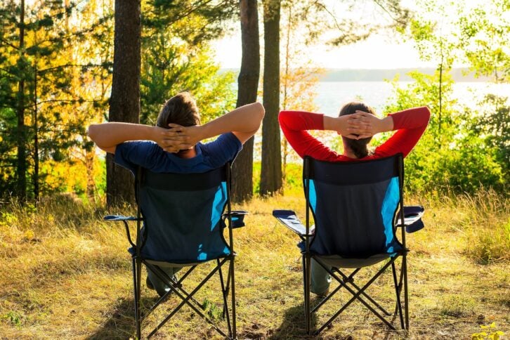 Man and woman relaxing at a campsite near the lake