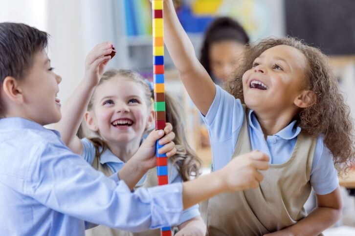 diverse preschool friends play with counting cubes