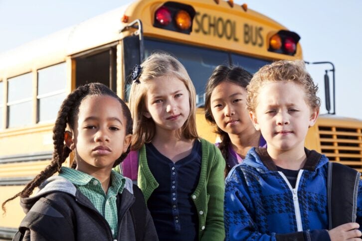 serious-looking children in front of schools