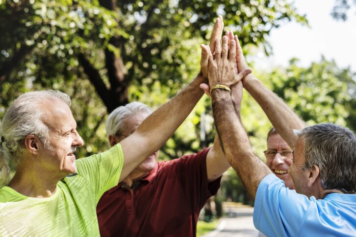 group of senior athletes giving a high five