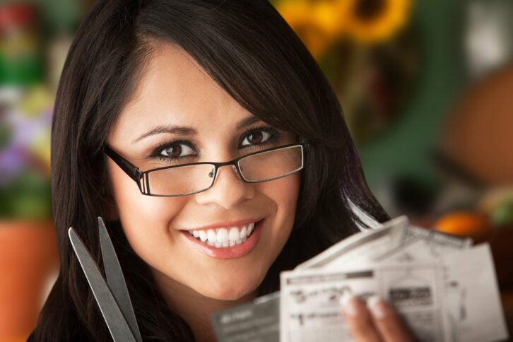 beautiful latina woman at table in kitchen with coupons
