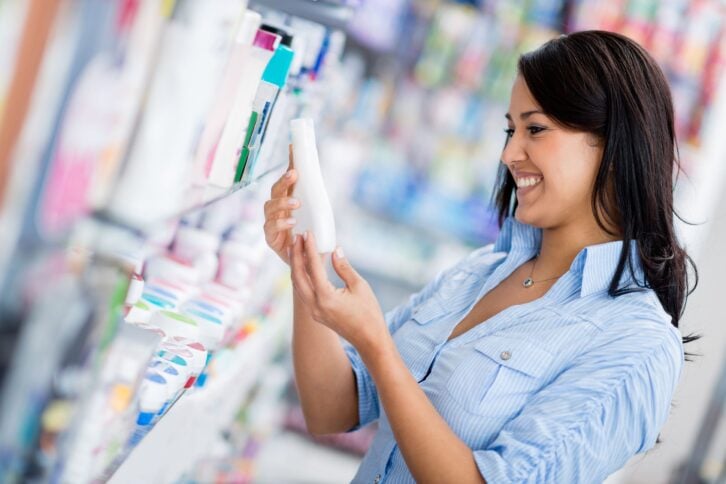 woman shopping for skin lotion in drug store