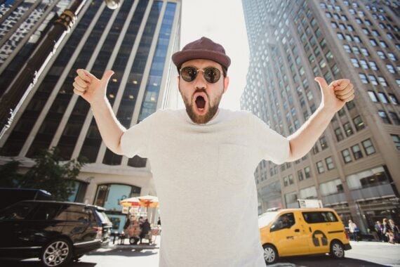 happy funny bearded man laughing and showing thumbs up in Manhattan
