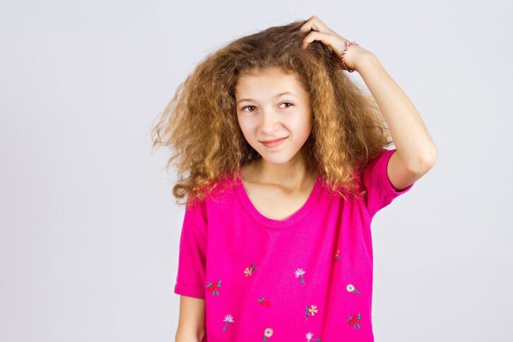 Young girl scratching her head