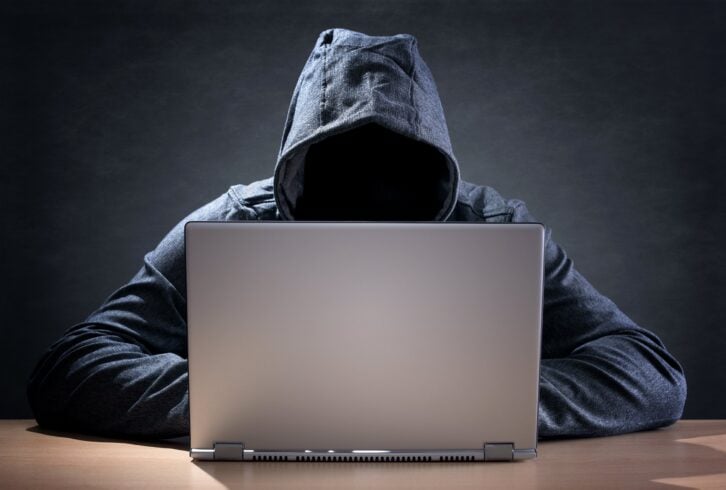 computer hacker stealing data from a laptop