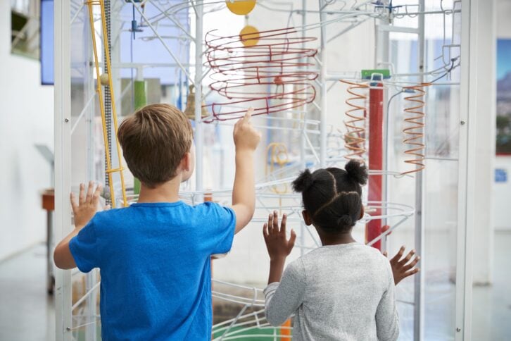 two kids looking at a science exhibit