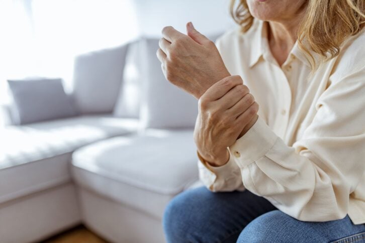 senior woman rubbing her wrist and arm suffering from rheumatism