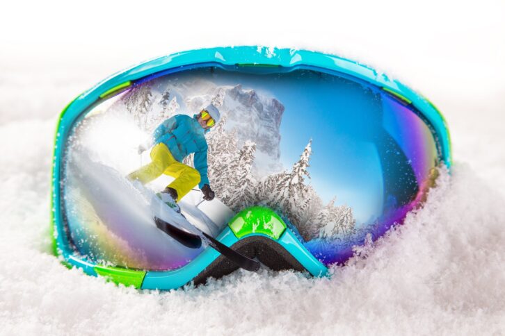 colorful ski glasses with skier on snow