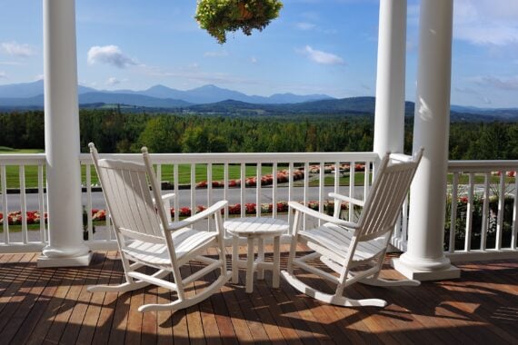 two relaxing armchairs overlooking peaceful mountain view on porch