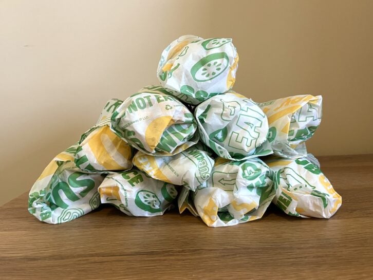 10 subway sandwiches in a pile