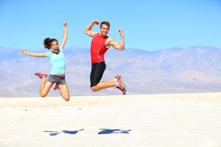 couple jumping happy and energetic in desert landscape