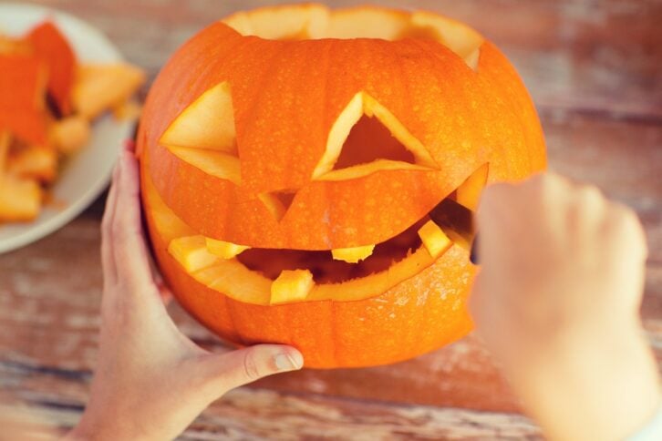 woman carving a pumpkin