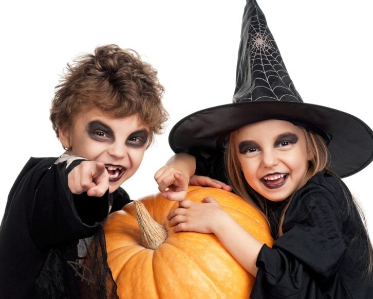 boy and girl wearing halloween costume with pumpkin