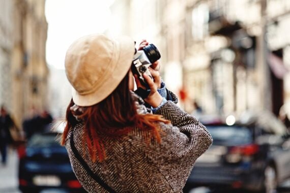 woman taking photo with camera of building
