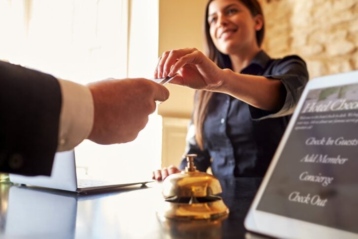 Guest checking into a hotel and taking the room key from front desk