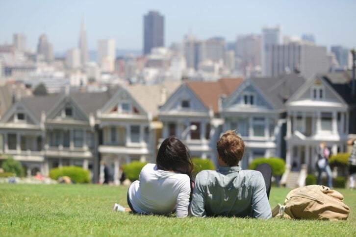couple laying on the grass in Alamo Square, San Francisco