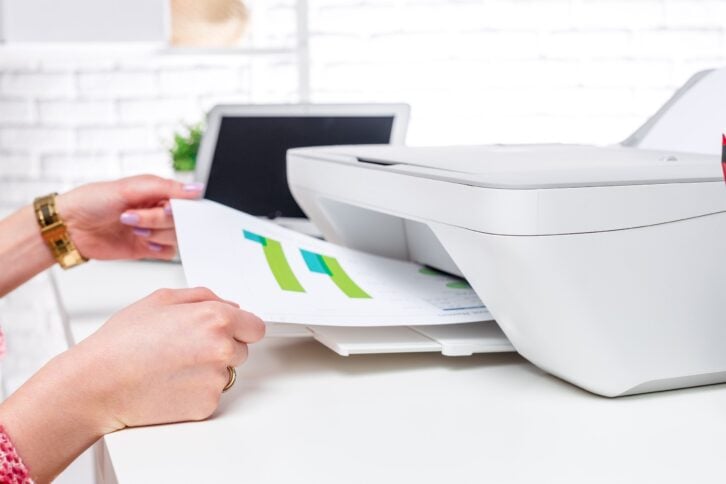 woman hands' getting paper newly printed from printer