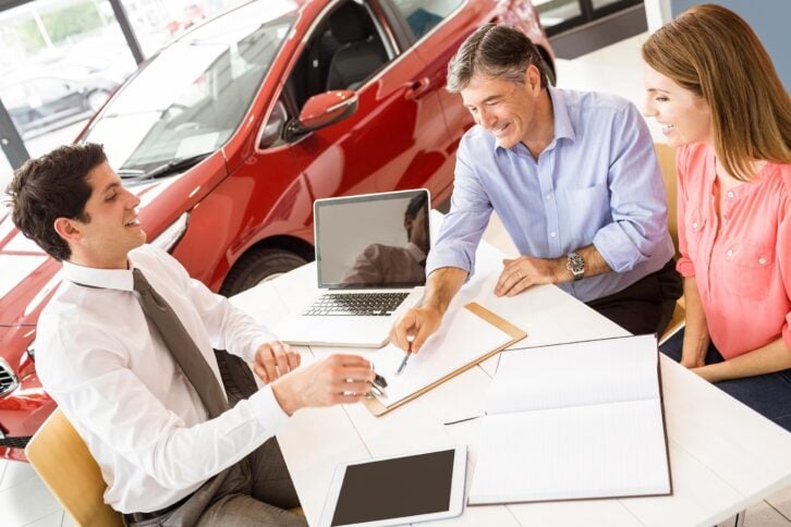customers signing some important documents at new car showroom