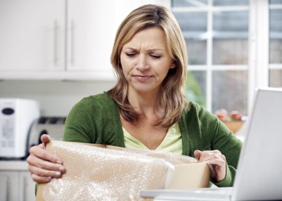 disappointed woman unpacking online purchase at home