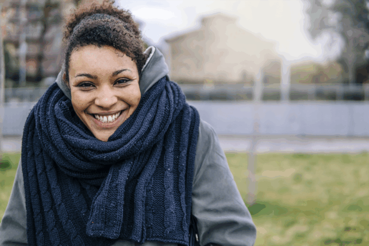 Young woman wearing winter clothes smiling at camera