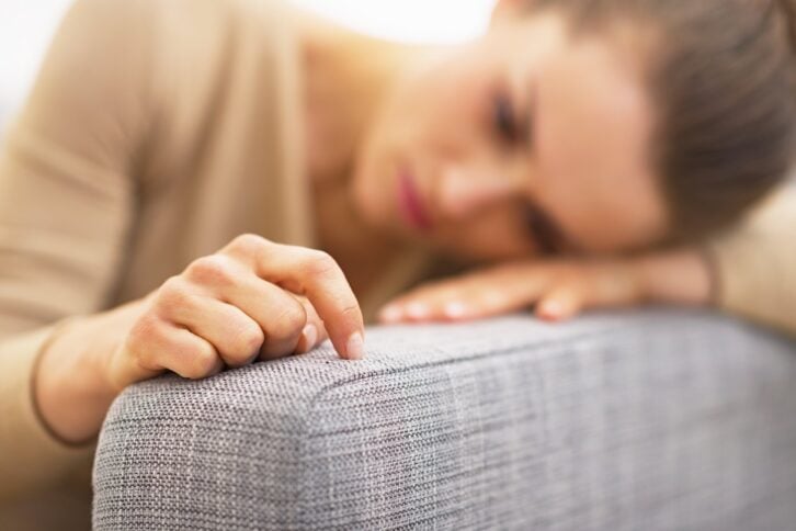 hand of frustrated young housewife sitting on couch