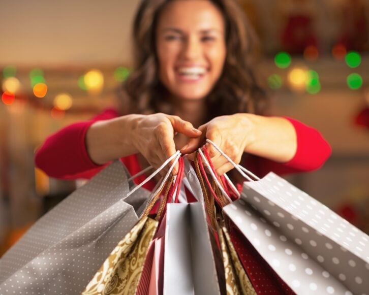 closeup on christmas shopping bags in hand of smiling woman