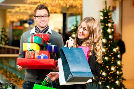 couple with Christmas presents and shopping bags in mall