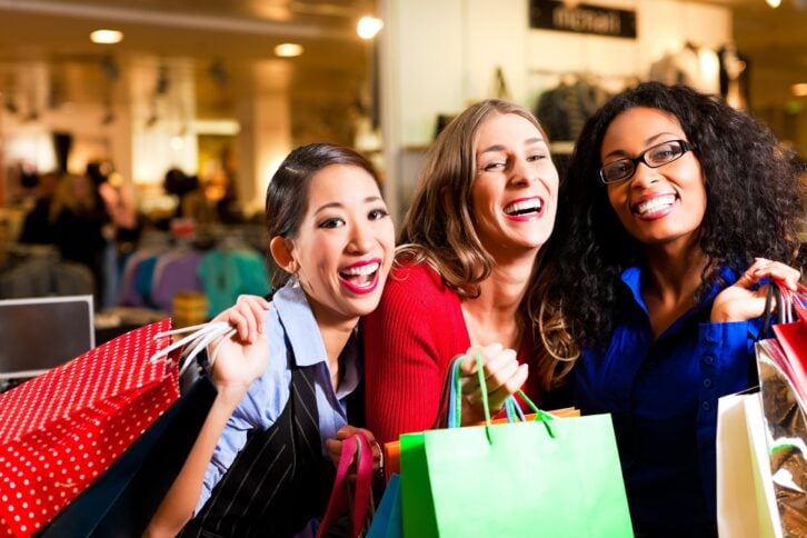 group of three women shopping in a mall