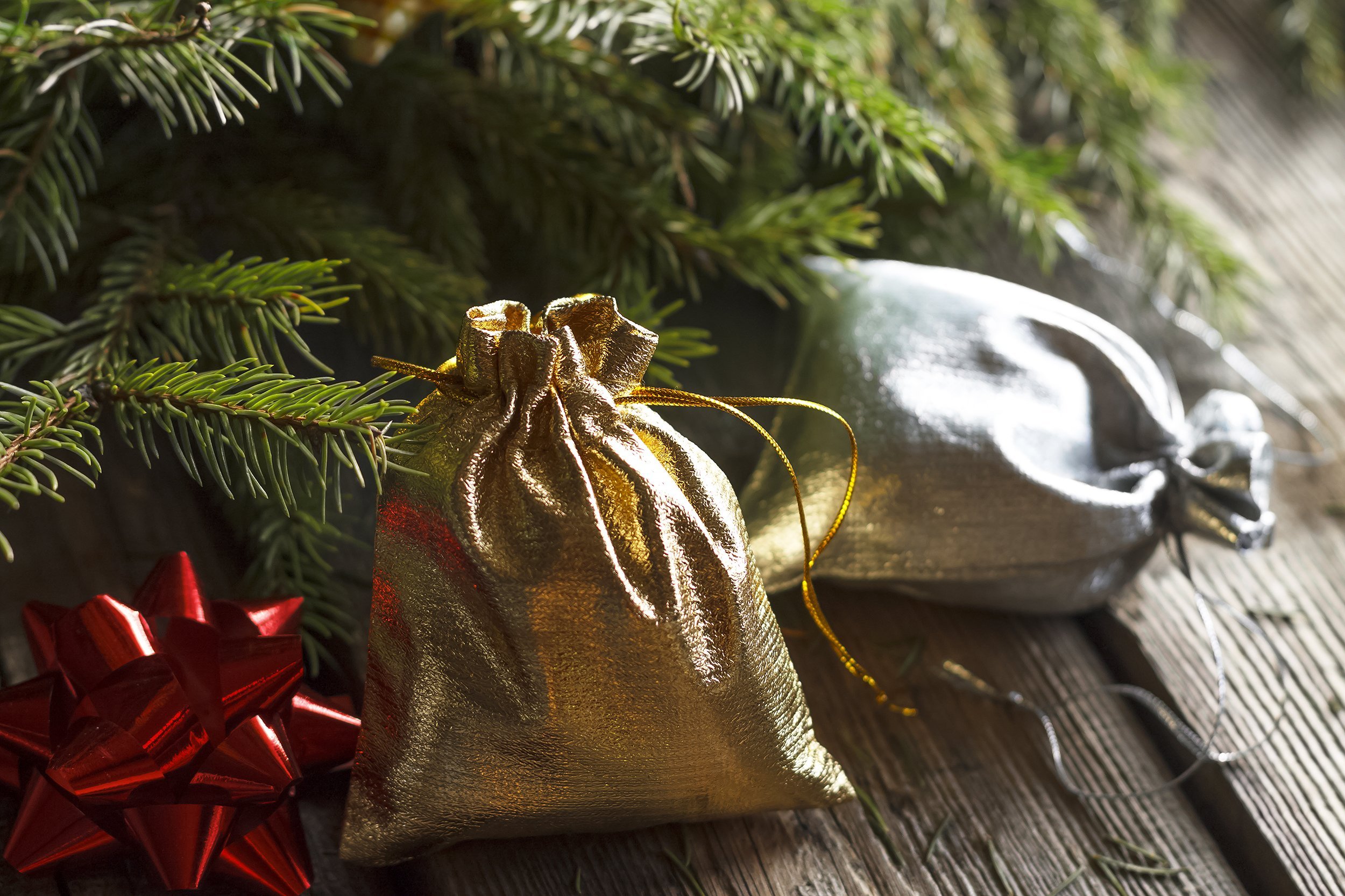small gift bags handmade in the branches of fluffy Christmas tree
