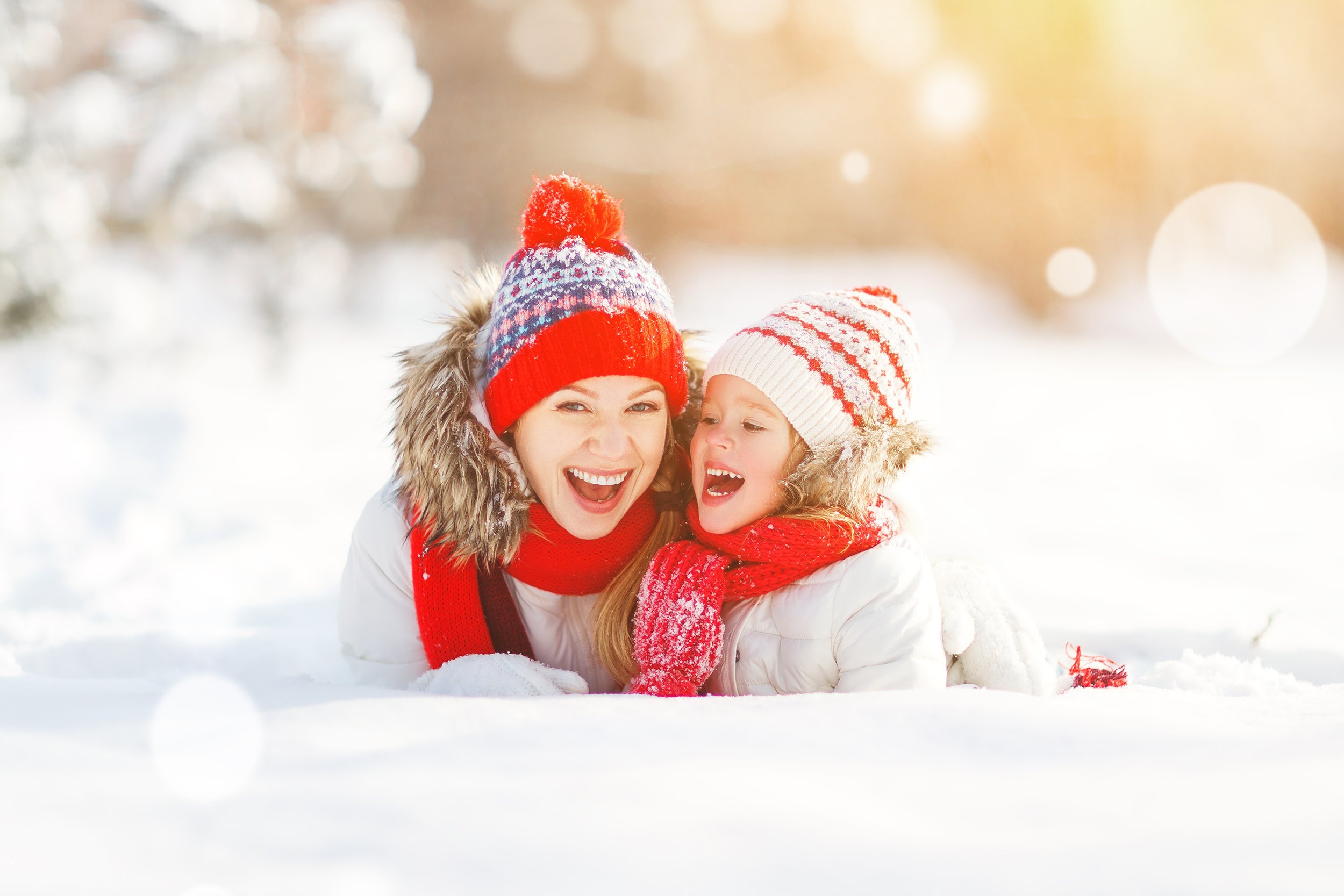 happy mother and child daughter laughing while in the snow
