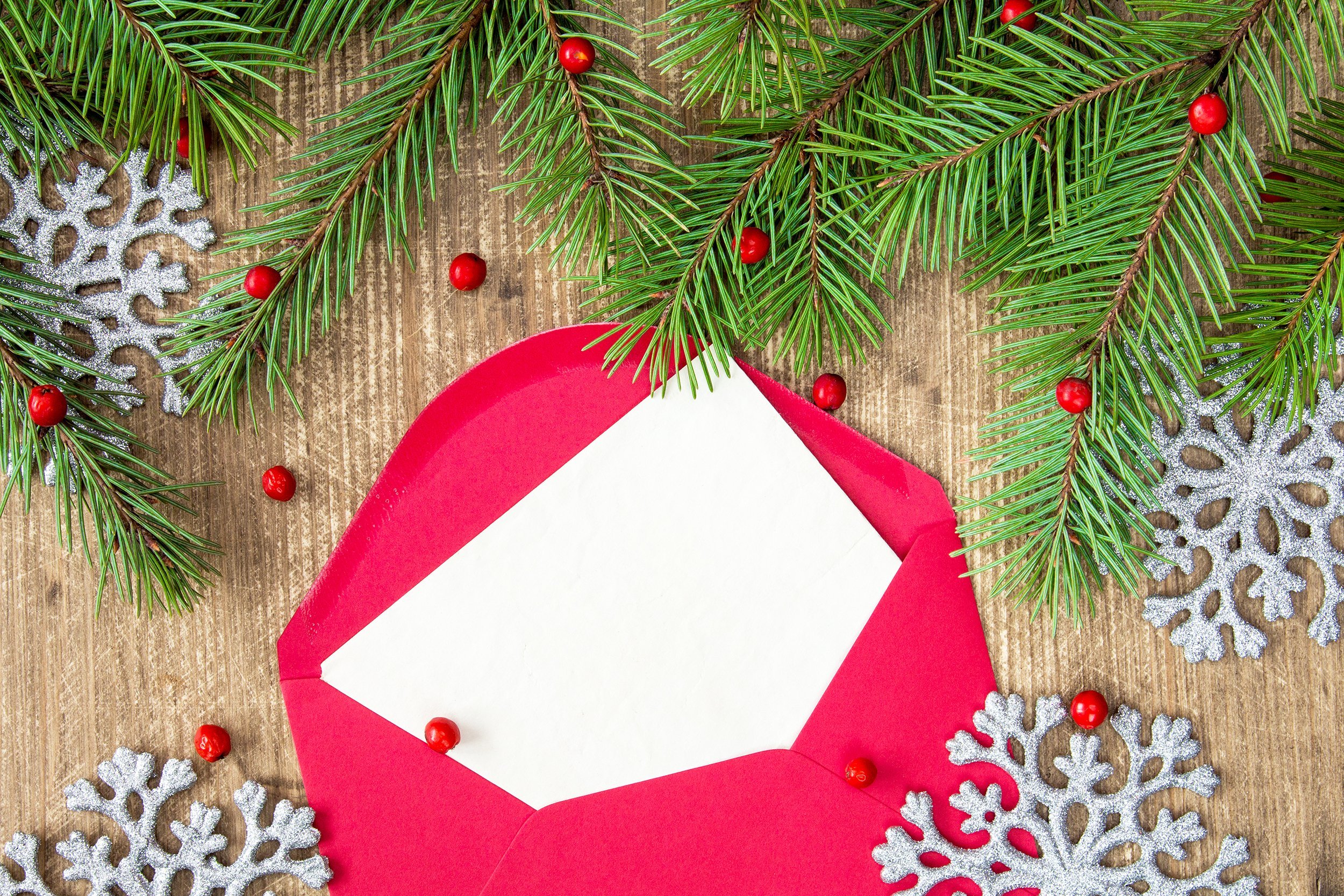 fir branch, silver shiny snowflakes and red envelope with a blank letter