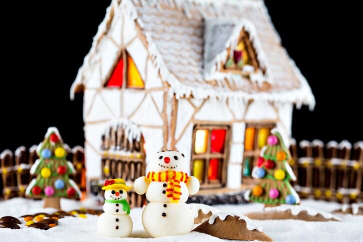 decorative snowmen and gingerbread house with lights inside