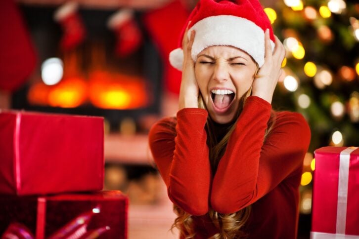 young woman wearing Santa's hat is screaming