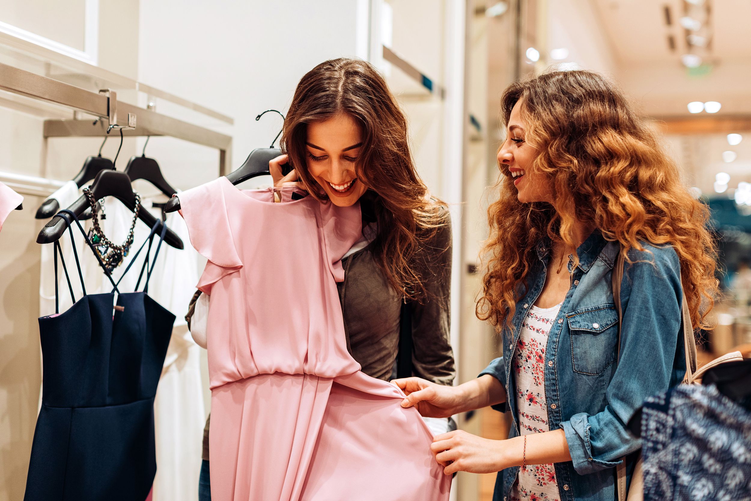 two young women choosing dresses in a luxury fashion store