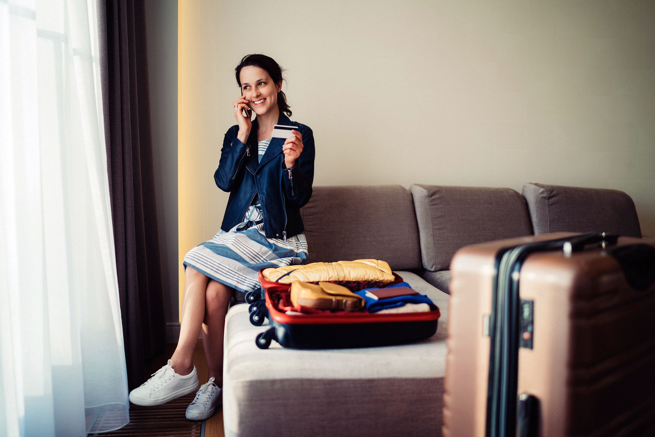tourist woman in hotel room making credit card reservation for flight