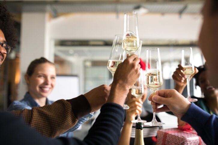 group of people toasting sparking wine during the holidays