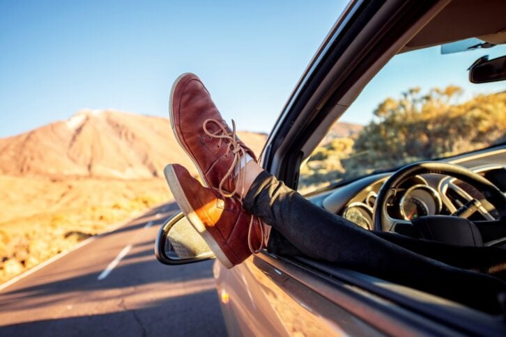 female legs on the vechicle window with casual shoes
