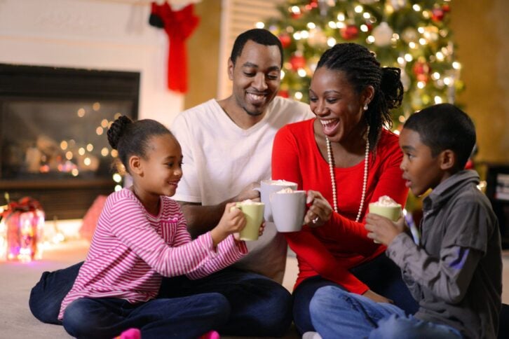 Family sitting at home during Christmas with mugs of cocoa