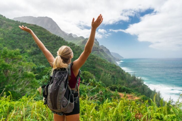 hiker with hands up in Kauai, Hawaii