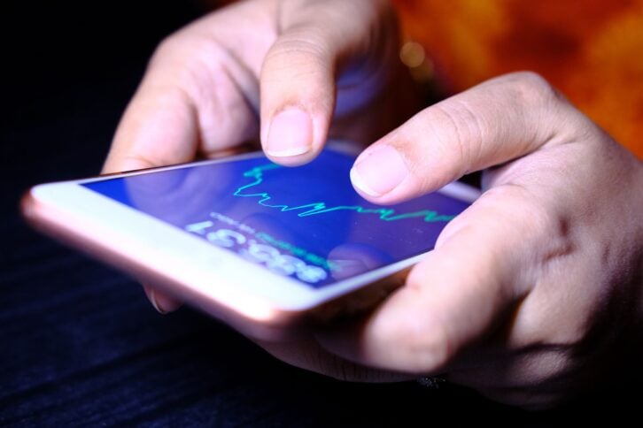 business women checking stock charts on a mobile device