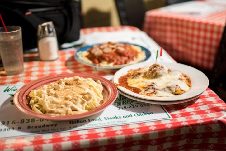Plates of pasta on a checkered table cloth at Savute's in Wichita, Kansas