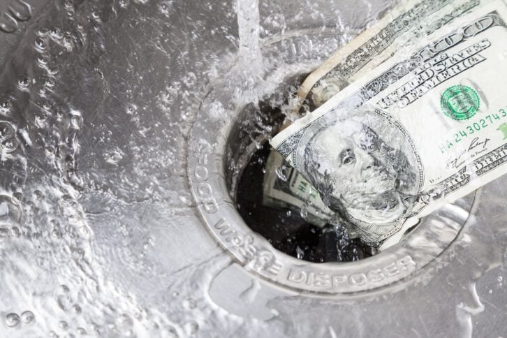 hundred dollar bills going down the drain