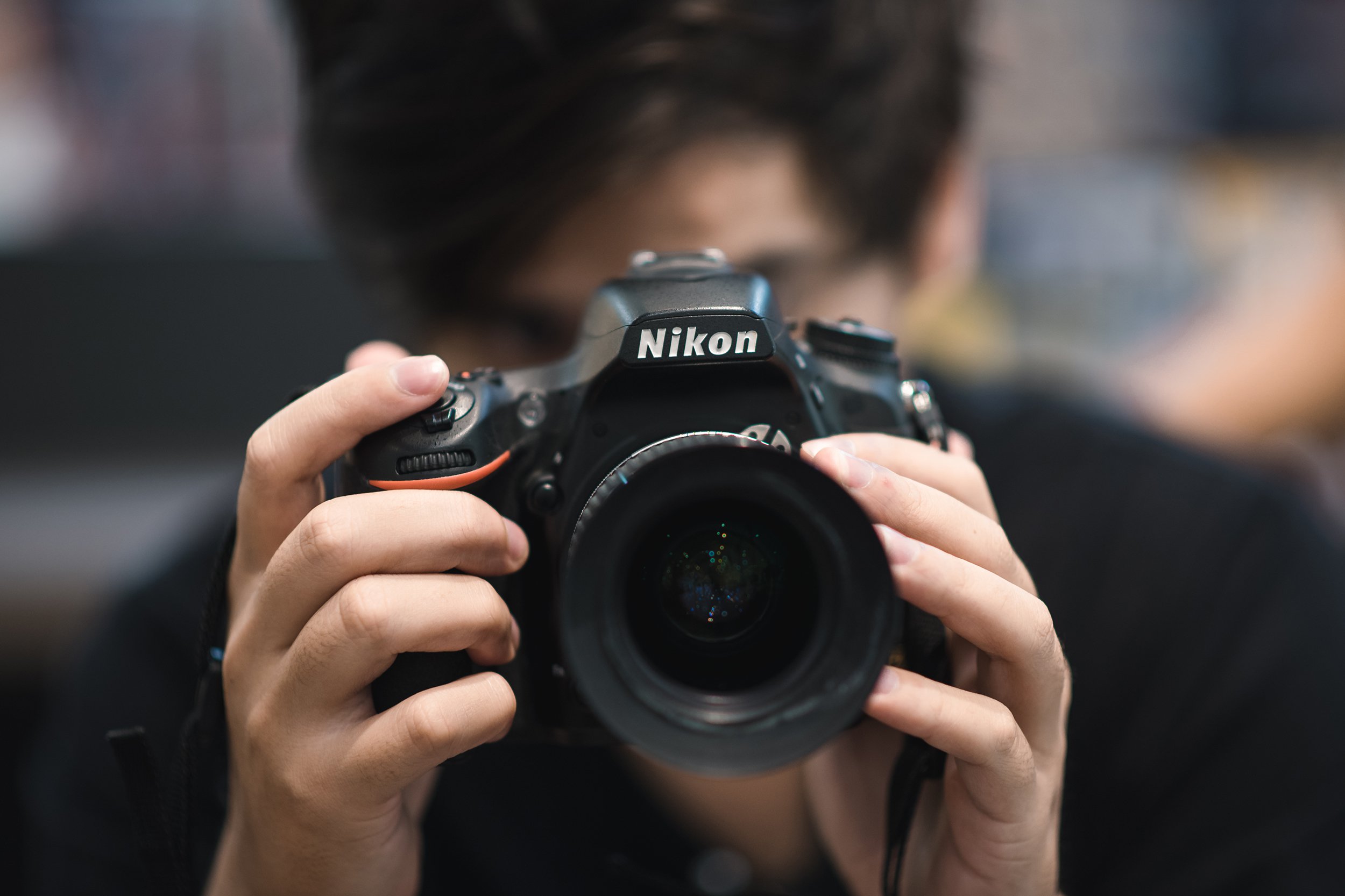 man taking photo with Nikon DSLR camera