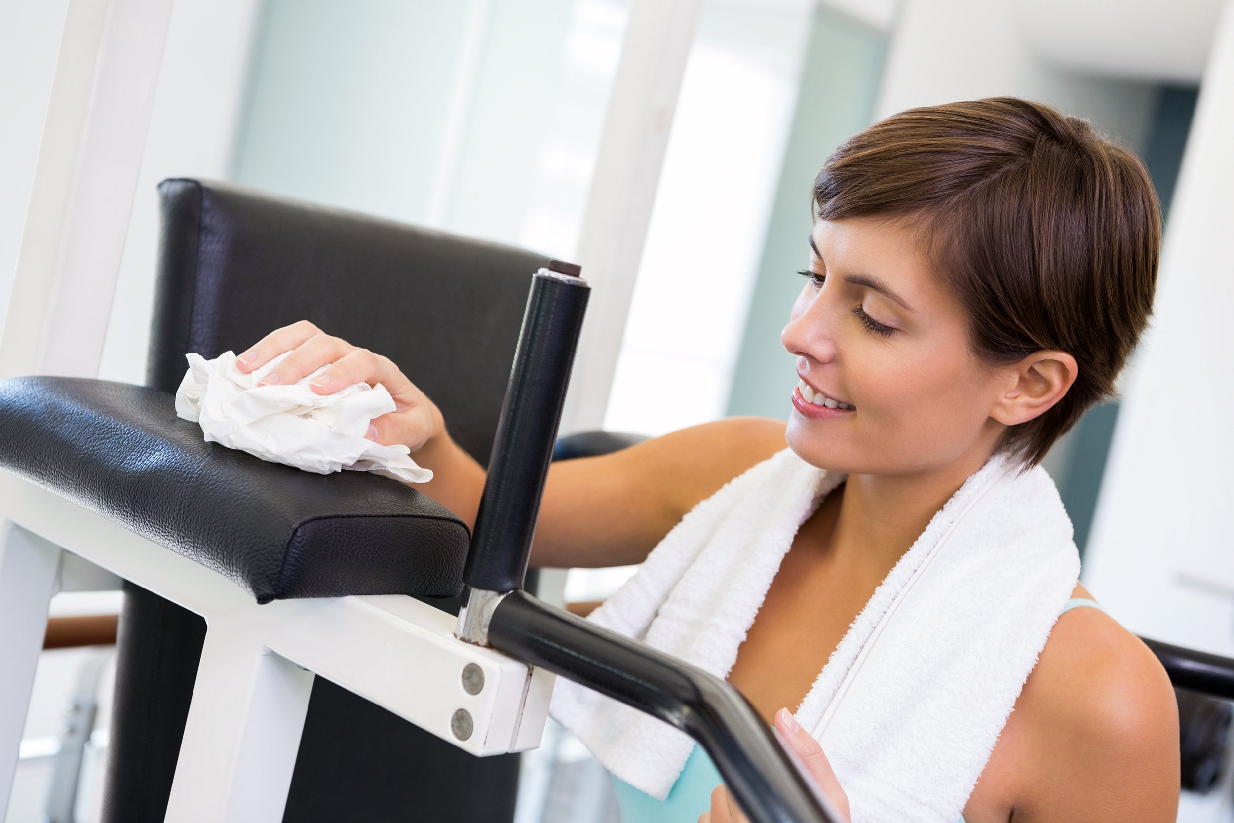 Woman cleaning a machine at the gym